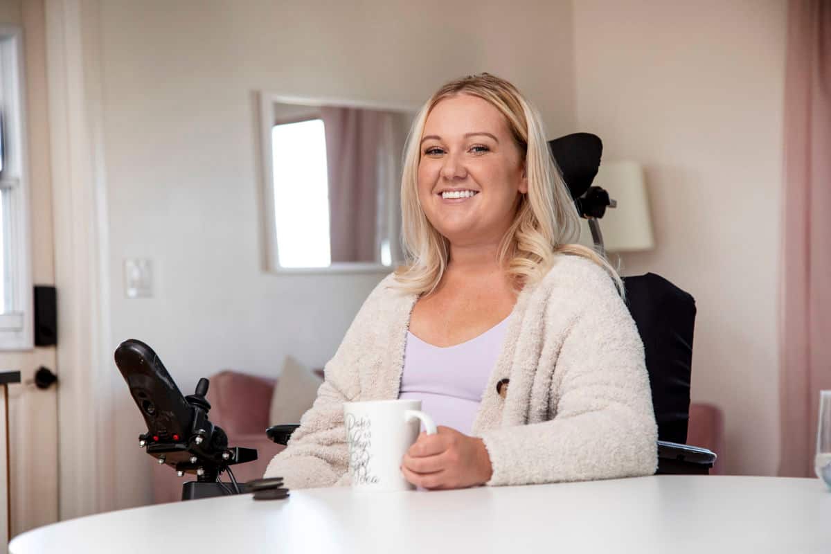 Female holding a mug in a wheelchair