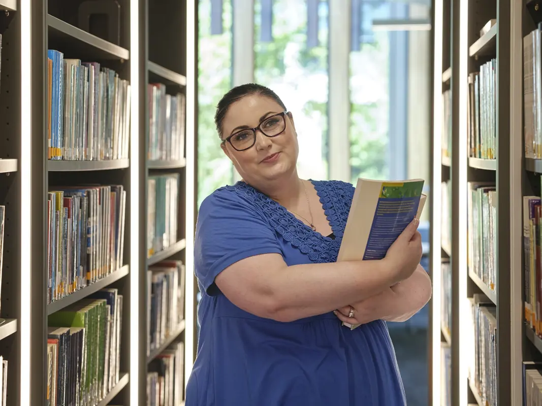 woman holding a book in a library